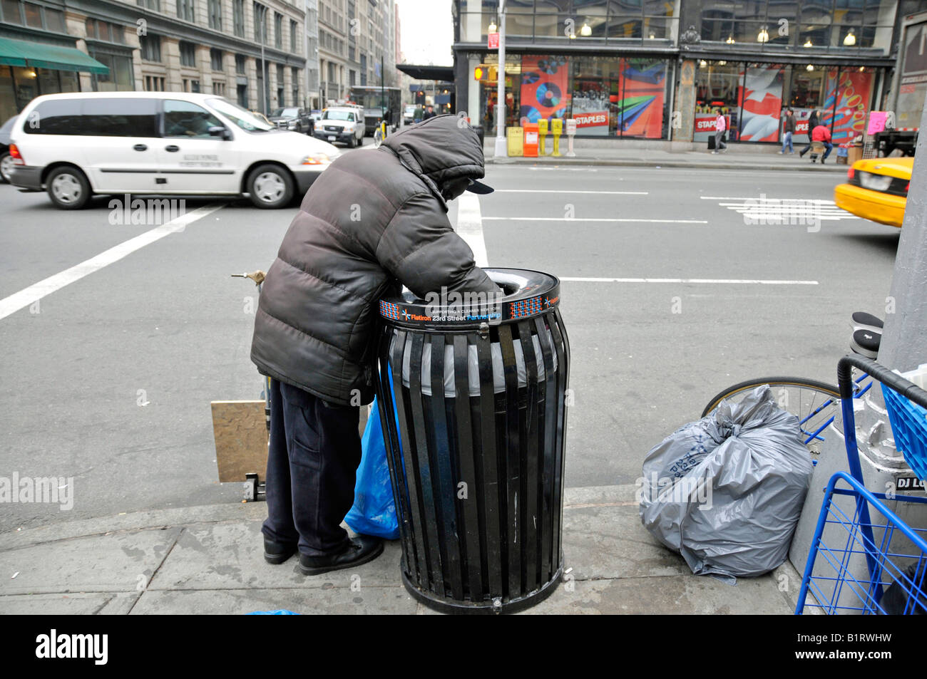 Personne sans-abri en fouillant dans une poubelle, à la recherche d'éléments réutilisables, Manhattan, New York City, USA Banque D'Images