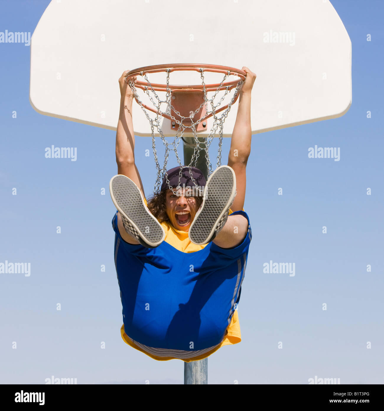 Un adolescent excité se bloque à partir d'un panier de basket-ball Banque D'Images