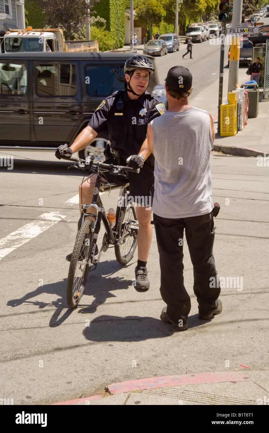 Un policier de vélo s'entretient avec un passant sur Fillmore Street à San Francisco, quartier Pacific Heights Banque D'Images