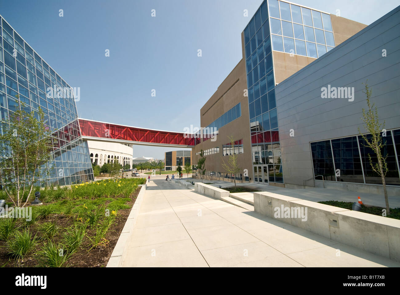 Ohio State University Student Wellness Center Overbridge Columbus // COLUMBUS, Ohio, États-Unis — L'extérieur du Ohio State University Student Wellness Center, un complexe de gymnase moderne, dispose d'un superbe pont piétonnier vitré rouge. Cette structure contemporaine, vue depuis Tuttle Park place, se trouve à proximité de l'emblématique Ohio Stadium, témoignant de l'engagement de l'université envers des installations étudiantes ultramodernes et une architecture innovante du campus. Banque D'Images
