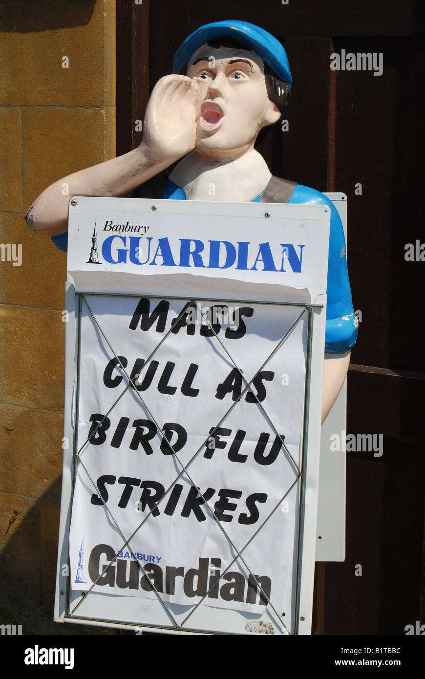 Paper-boy stand avec Banbury Guardian newspaper headlines , High Street, Chipping Norton, Oxfordshire, Angleterre, Royaume-Uni Banque D'Images