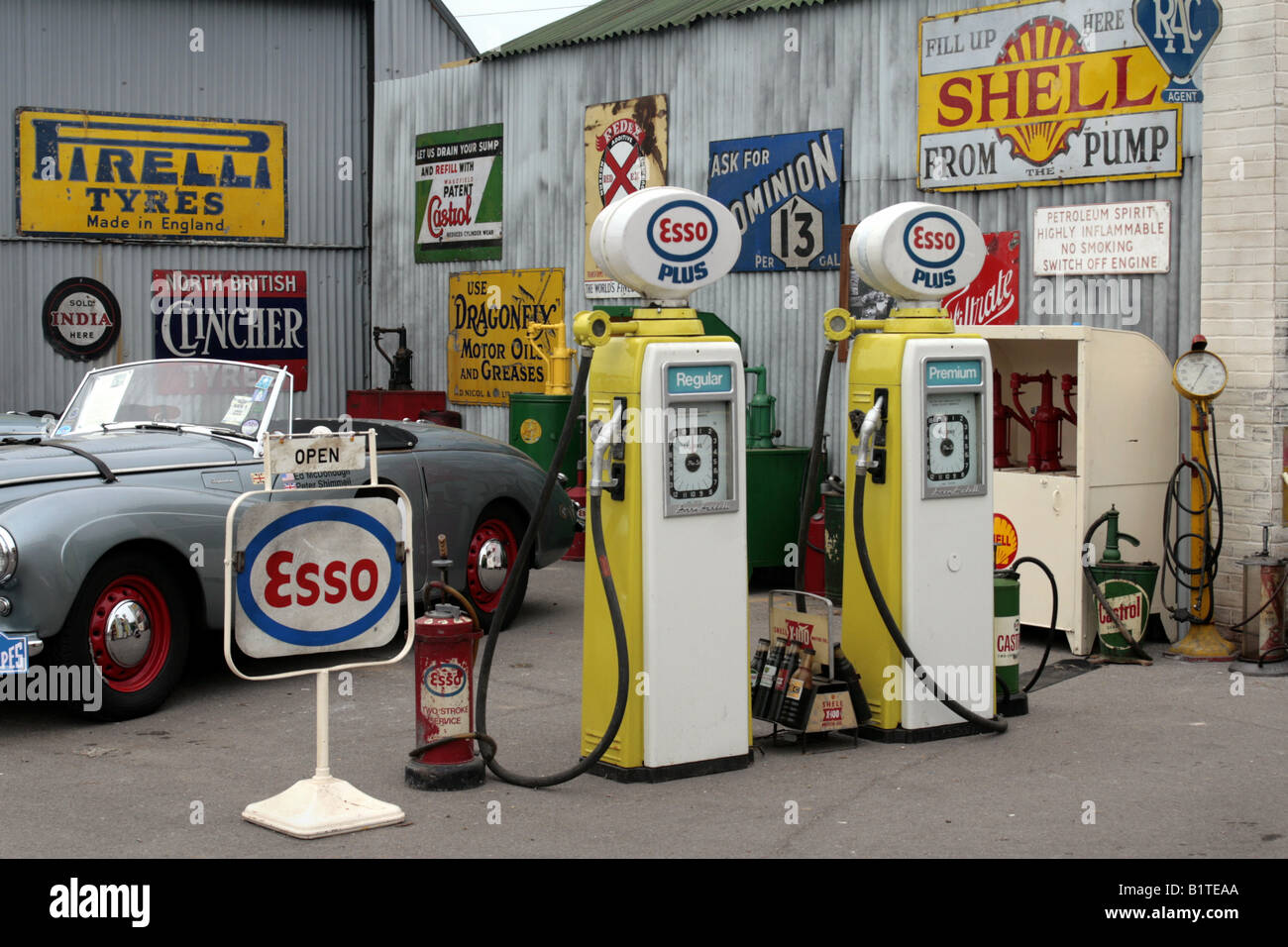 Un garage avant-cour jonchée de panneaux publicitaires mémorables et accessoires à Goodwood Revival meeting Septembre 2007. Banque D'Images