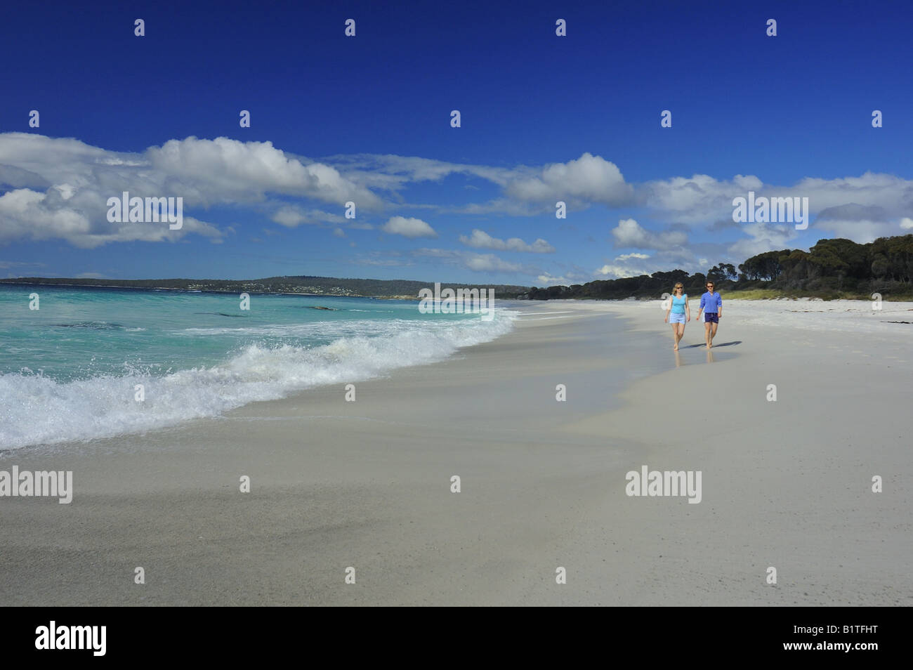 Deux jeunes femmes à pied le long d'une plage de sable en Tasmanie. L'espace pour copier dans le ciel. Banque D'Images