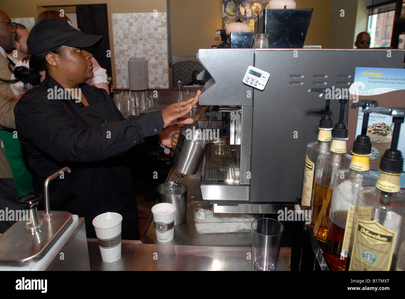 Un Starbucks employés prépare un verre dans un nouveau café sur Frederick Douglass Boulevard à Harlem à New York Banque D'Images