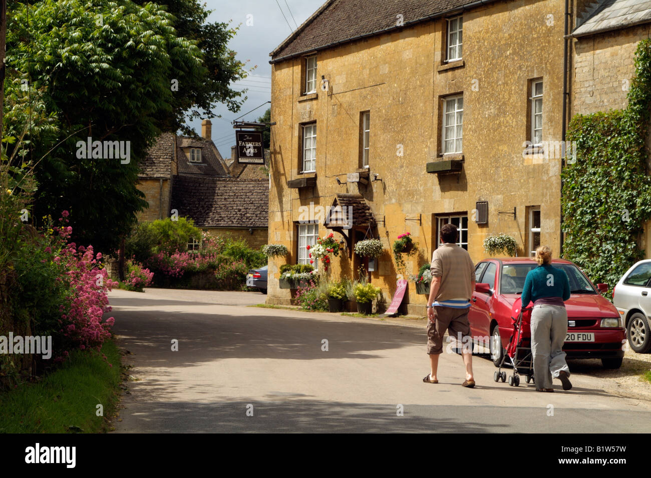 English country pub dans le village de Cotswolds Gloucestershire Angleterre Guiting Power family on country walk Banque D'Images