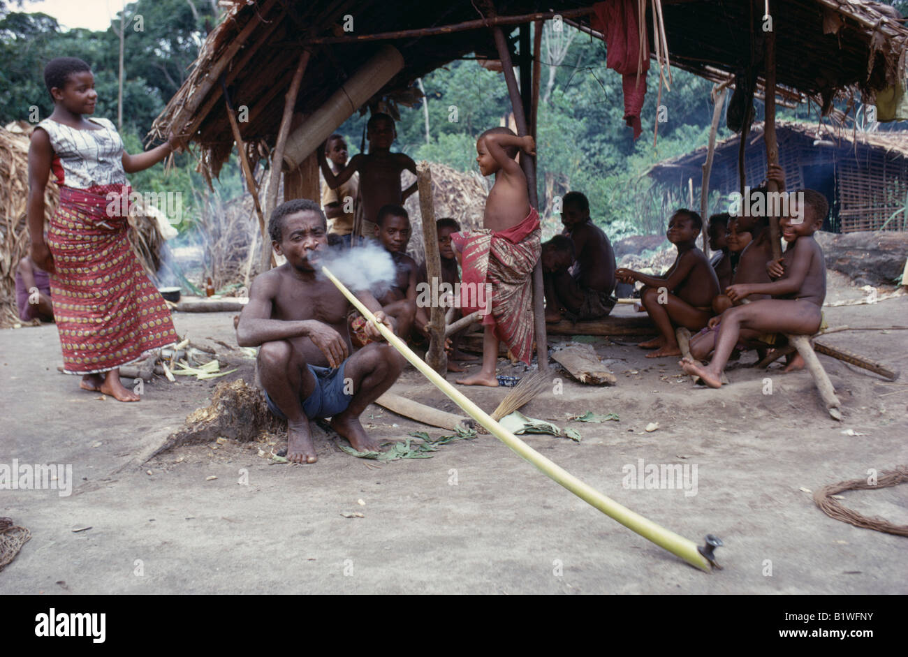 CONGO Afrique Centrale De La Forêt de l'Ituri de groupe pygmée Twa forestiers nomades avec l'homme des personnes fumeurs hallucinogènes à long tuyau Banque D'Images