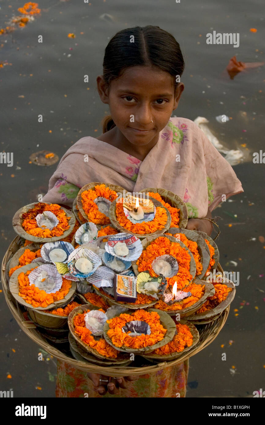 Belle jeune fille vendre des guirlandes sur un ghat de Varanasi, Inde Banque D'Images