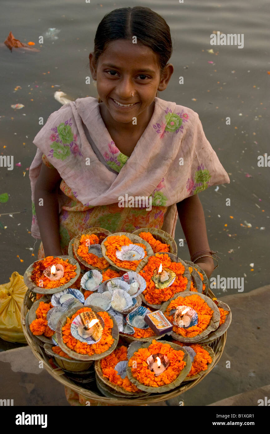 Belle jeune fille vendre des guirlandes sur un ghat de Varanasi, Inde Banque D'Images