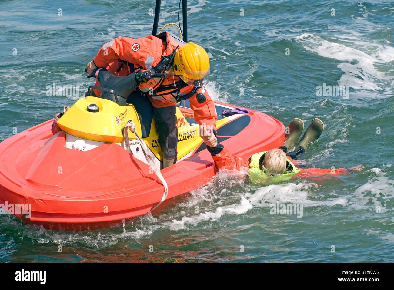 Batelier de sauvetage en mer en détresse sauve personne et obtient pour lui hors de l'eau avec facilité et rapidité Banque D'Images