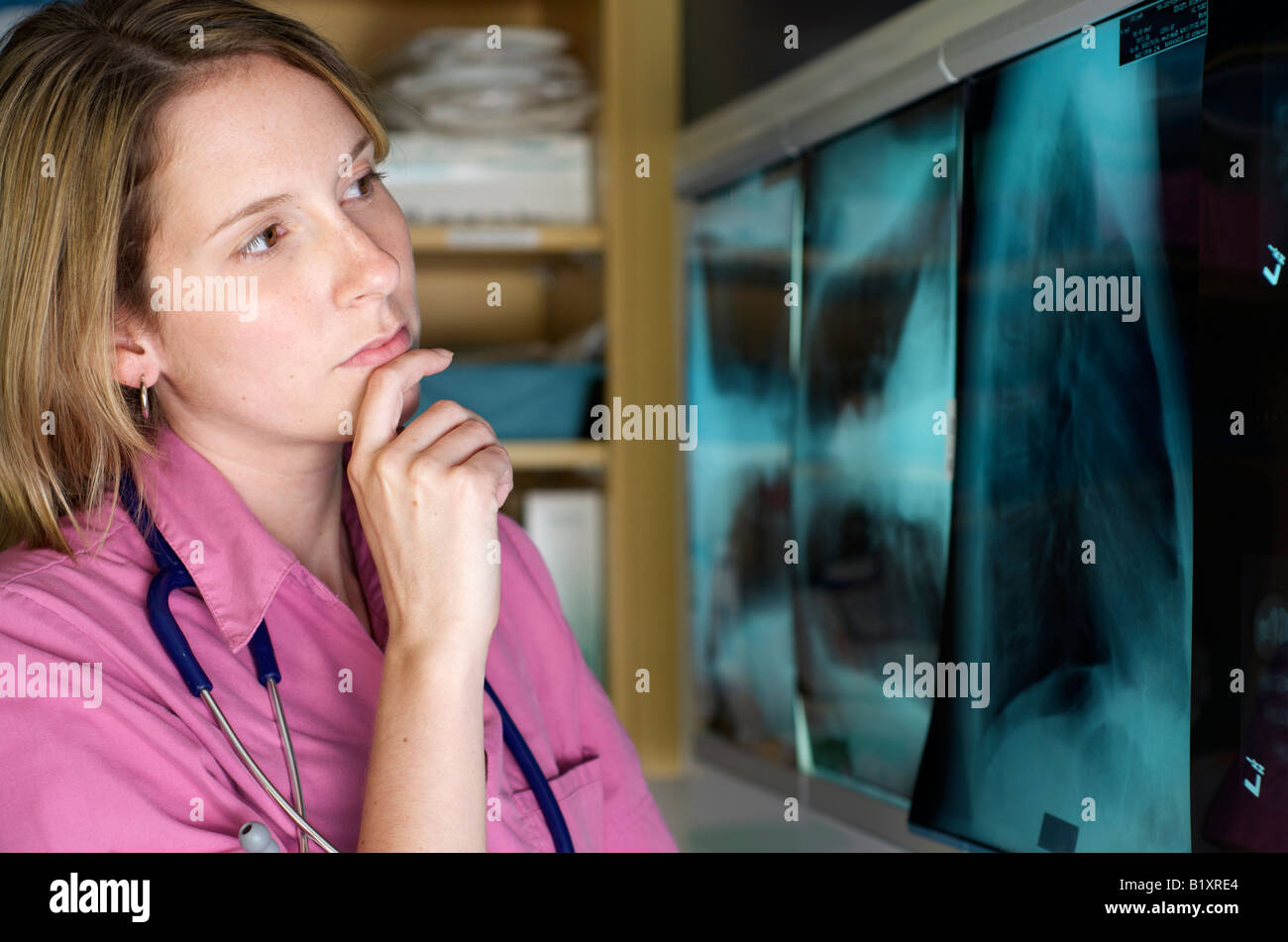 Dans scrubs infirmier stéthoscope avec examen de Xray. Paramètre d'arrière-plan de l'hôpital. Banque D'Images