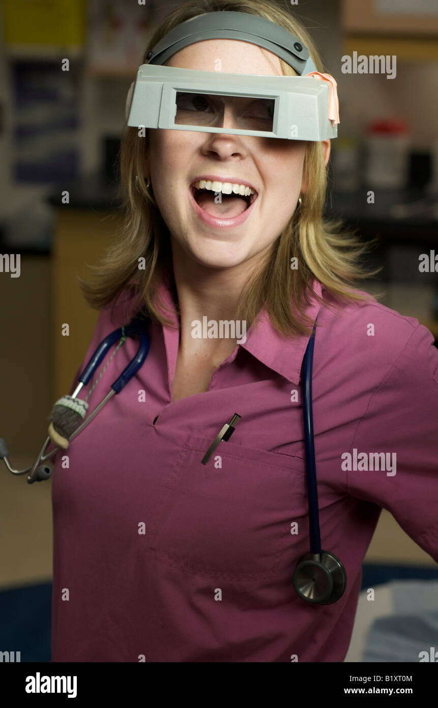 Infirmière avec drôle de lunettes avec un grand sourire qui posent. Moitié du corps, posture. Banque D'Images