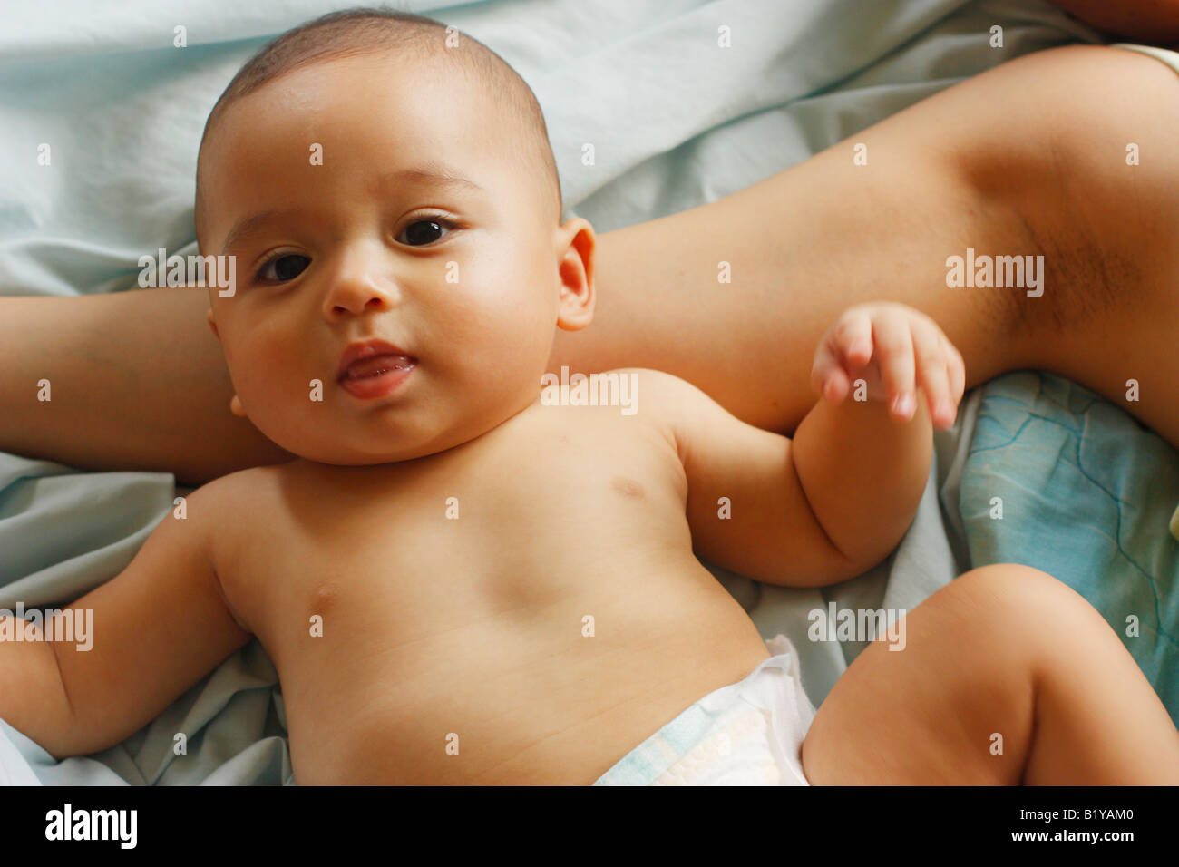 5 mois bébé garçon jouant sur le bras de la mère ; Bébé est la moitié et la moitié de l'Asie Caucasian Banque D'Images