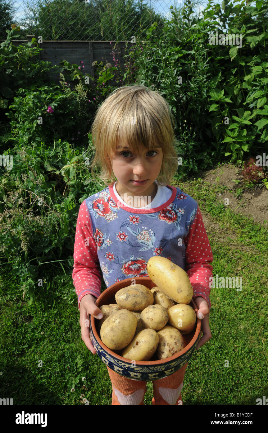 Young Girl holding freshly dug-pomme Banque D'Images
