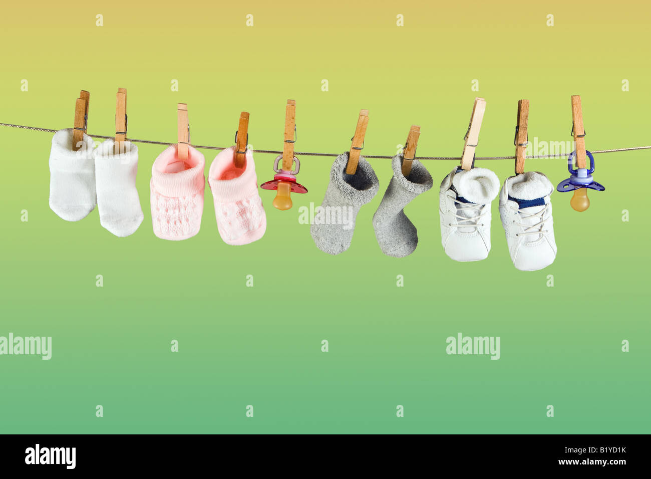 Chaussettes et chaussures bébé suspendu à une corde dans le ciel Banque D'Images