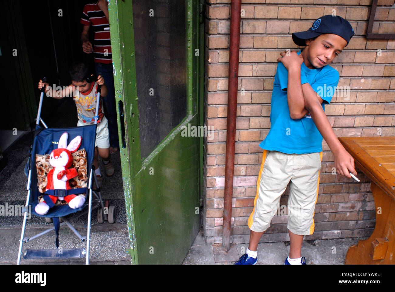 Mihai, 11 ans, fume une cigarette, dans la cour de Ioana refuge pour les sans-abri, où il vit avec sa mère Banque D'Images