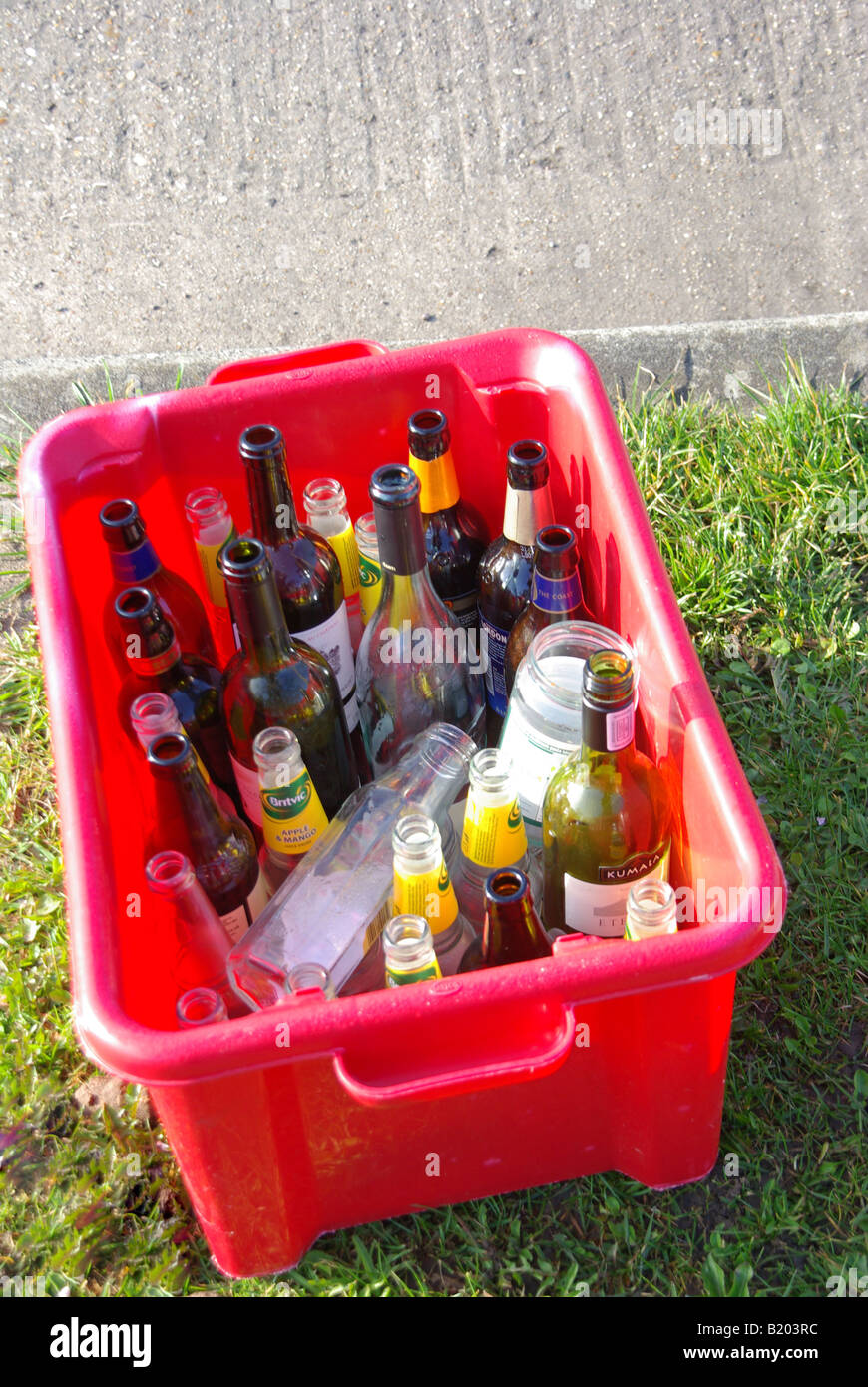 Trier les déchets ménagers en verre recyclable boîte rouge placée en bordure de la collection attendent Banque D'Images