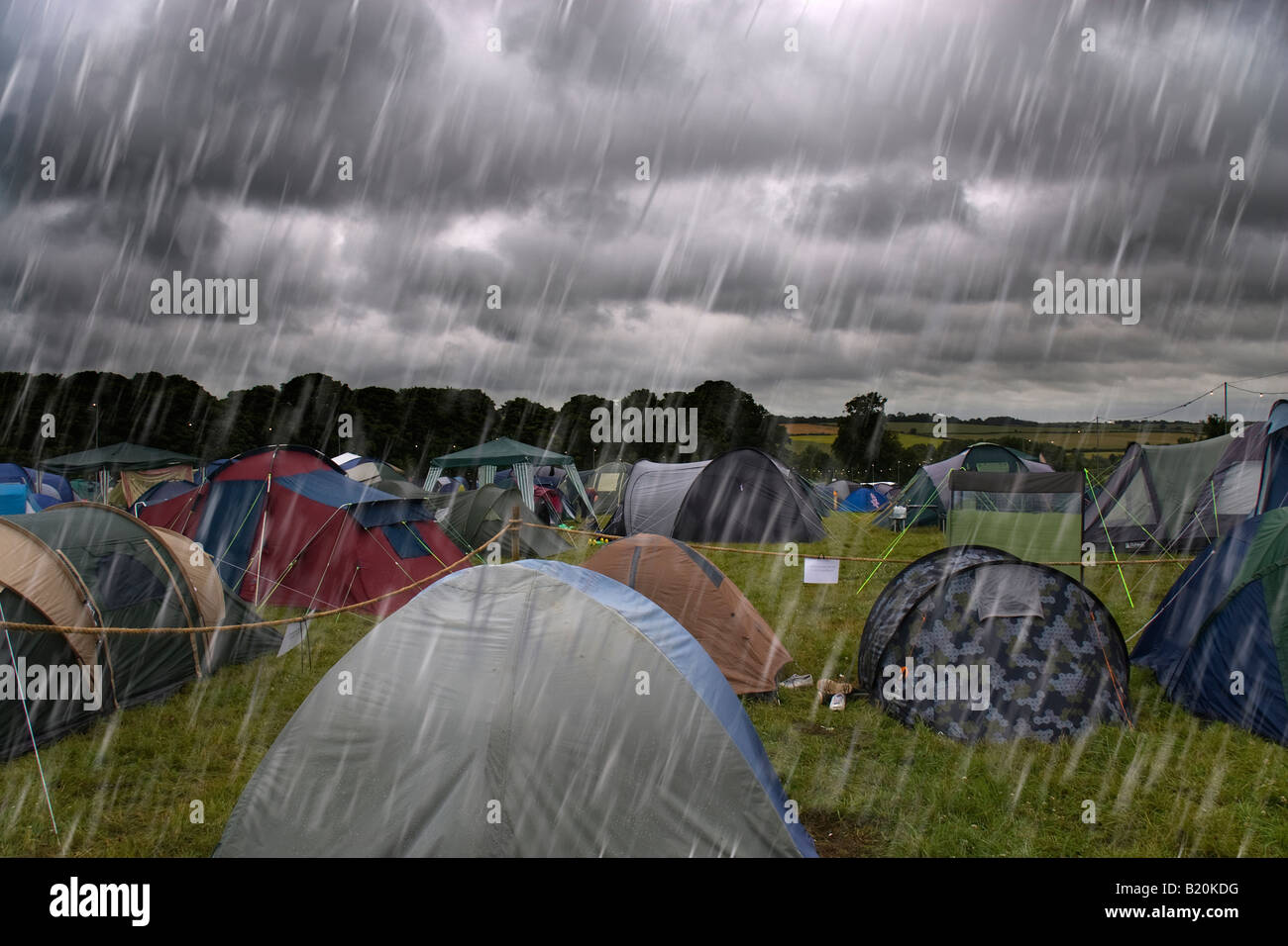 Des nuages sombres dans le ciel avec des pluies torrentielles qui tombent sur des tentes dans un camping à l'Cornbury Music Festival Banque D'Images