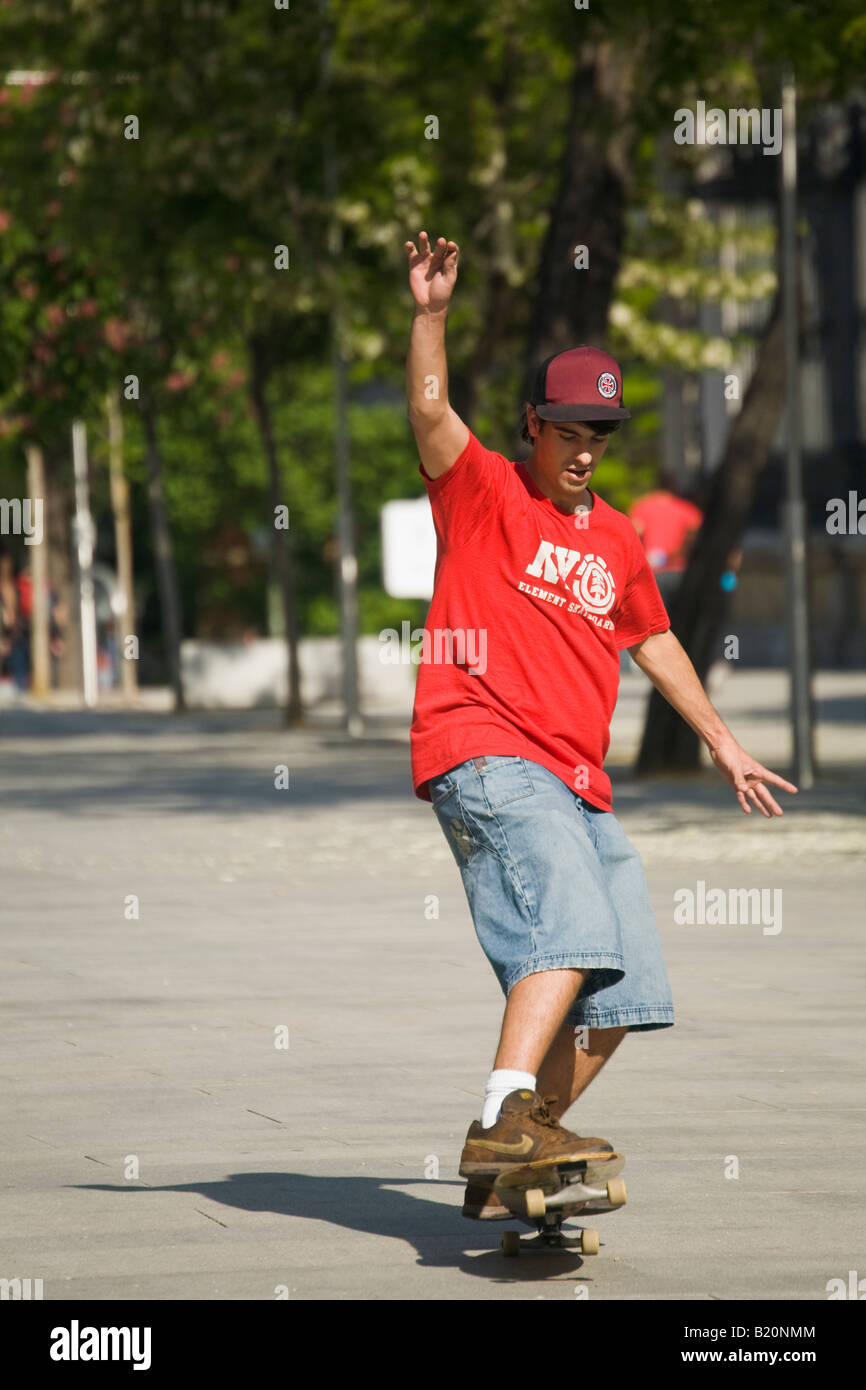 Espagne Madrid Les jeunes adultes de sexe masculin Ride skateboard bas trottoir roues avant de bord au-dessus du sol Banque D'Images