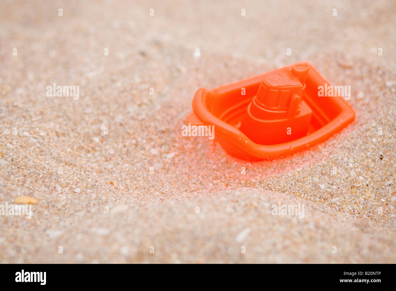Bateau jouet en plastique dans le sable. Banque D'Images