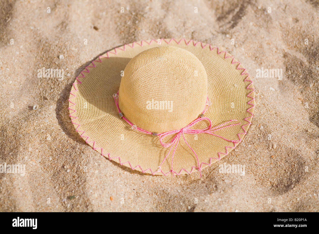 Sun hat tissé dans le sable sur la plage Banque D'Images