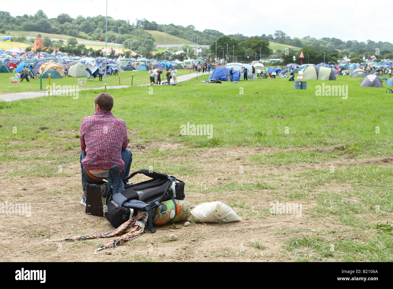 Festival de musique de Glastonbury 2008 jeune homme prend un reste assis sur son sac à dos avec une assurance à la recherche sur le site sur le premier jour de l'arrivée Banque D'Images