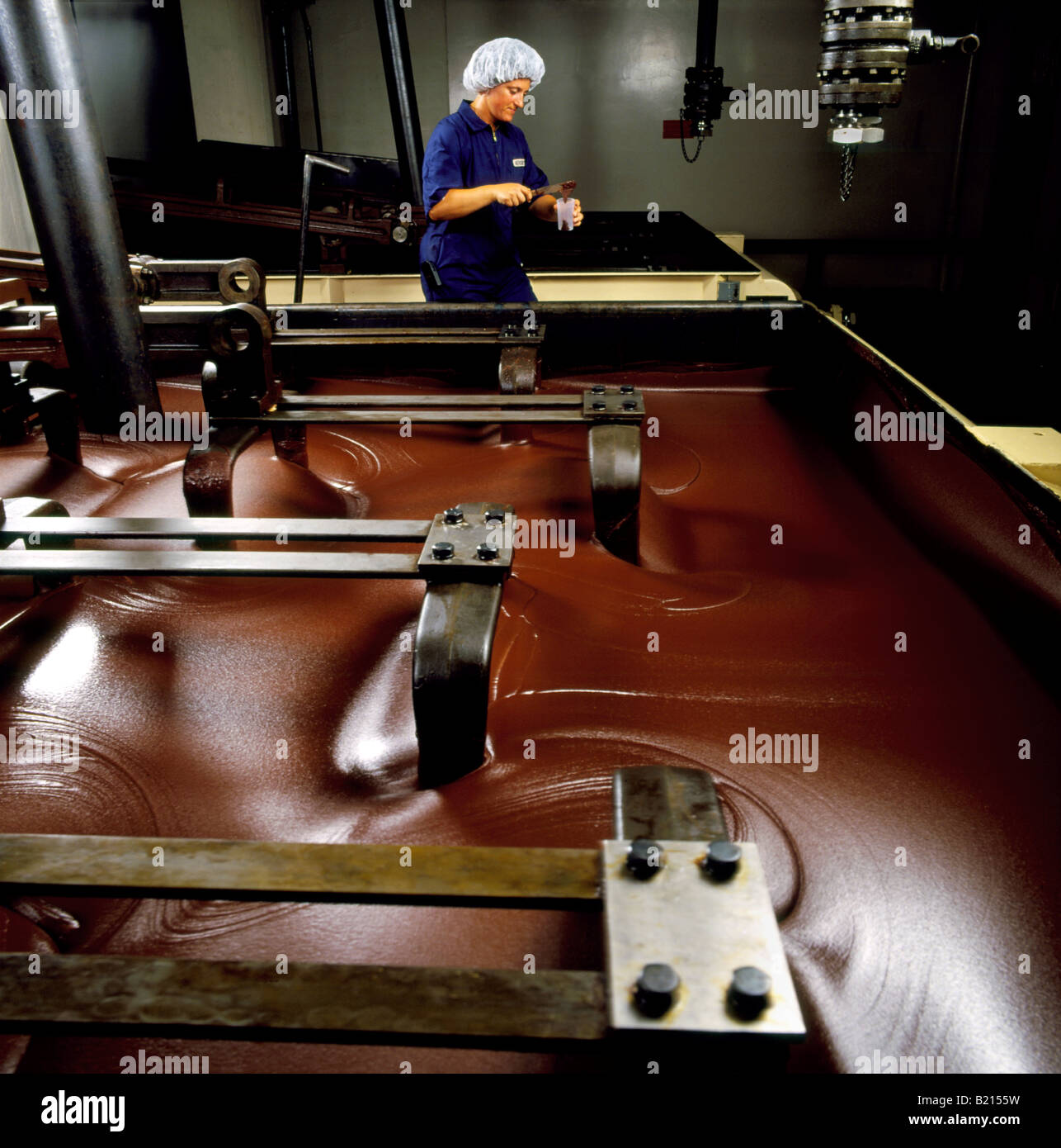 Technicien de contrôle de la qualité vérifie la production d'une grande cuve de chocolat de Hershey Foods. Banque D'Images
