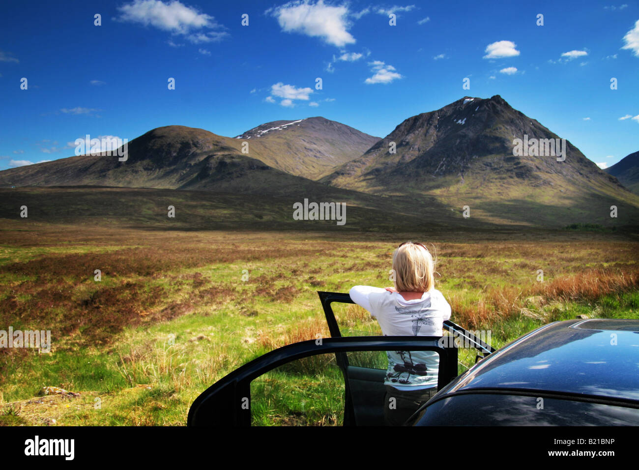 Une femme à côté d'une voiture à la montagne à Banque D'Images