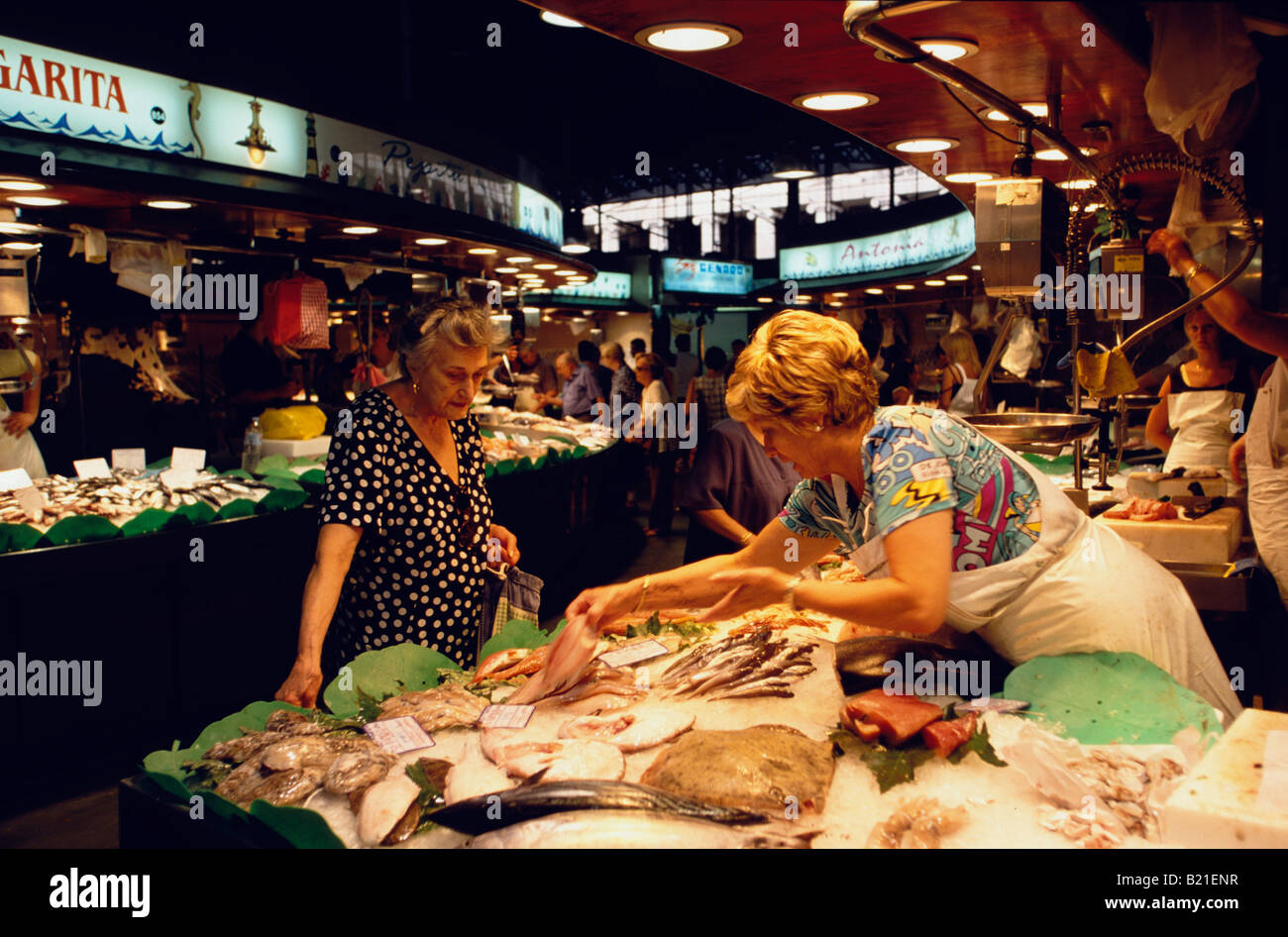 La femme est l'achat à la poissonnerie du Mercat de la Boqueria dans le Raval Ramblas de Barcelone Catalogne Espagne Banque D'Images