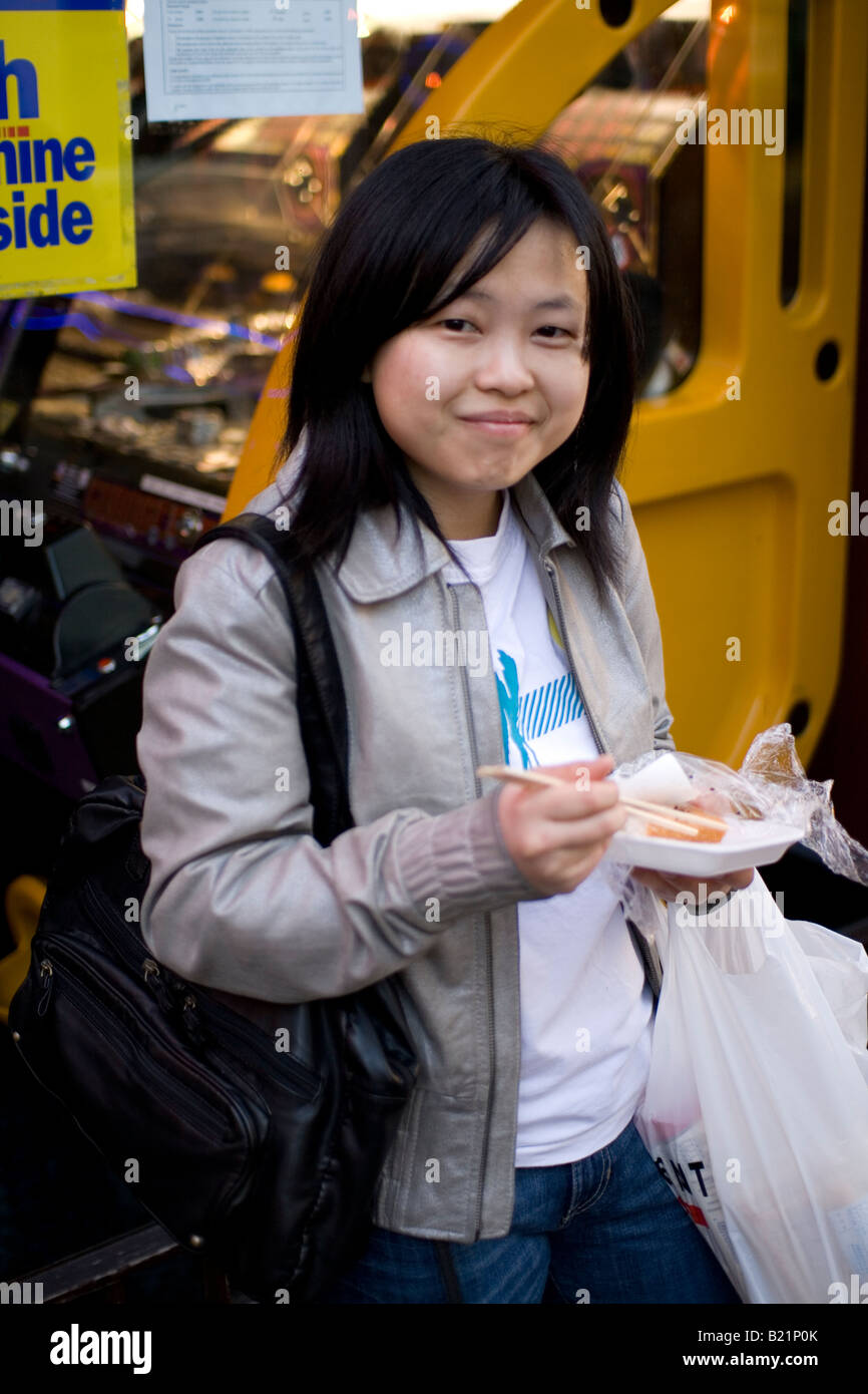 Une fille mange des aliments chinois China Town à Londres Banque D'Images