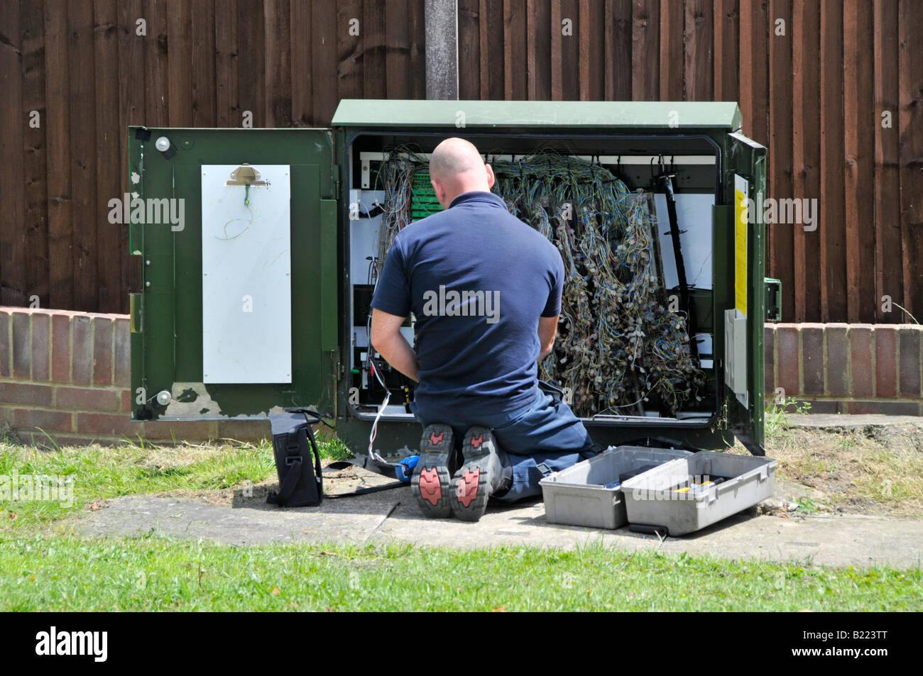 BT ingénieur travaillant sur les câbles dans l'armoire de la route Banque D'Images
