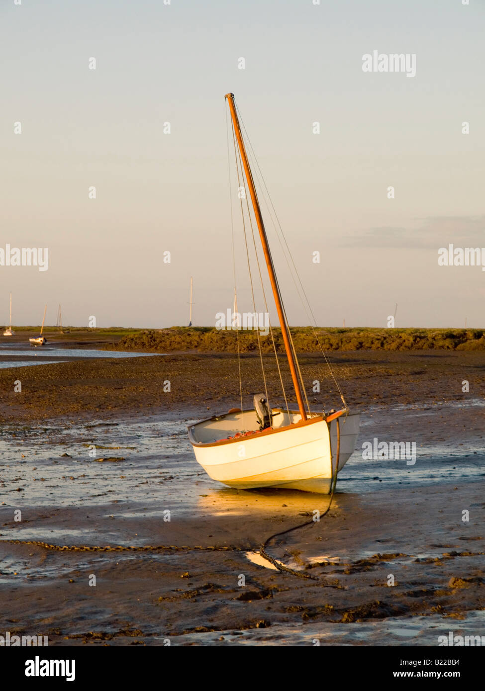 Un seul bateau sur la vase à marée basse. Coucher du soleil dans le village de Burnham Deepdale sur la côte nord du comté de Norfolk dans l'East Anglia UK Banque D'Images