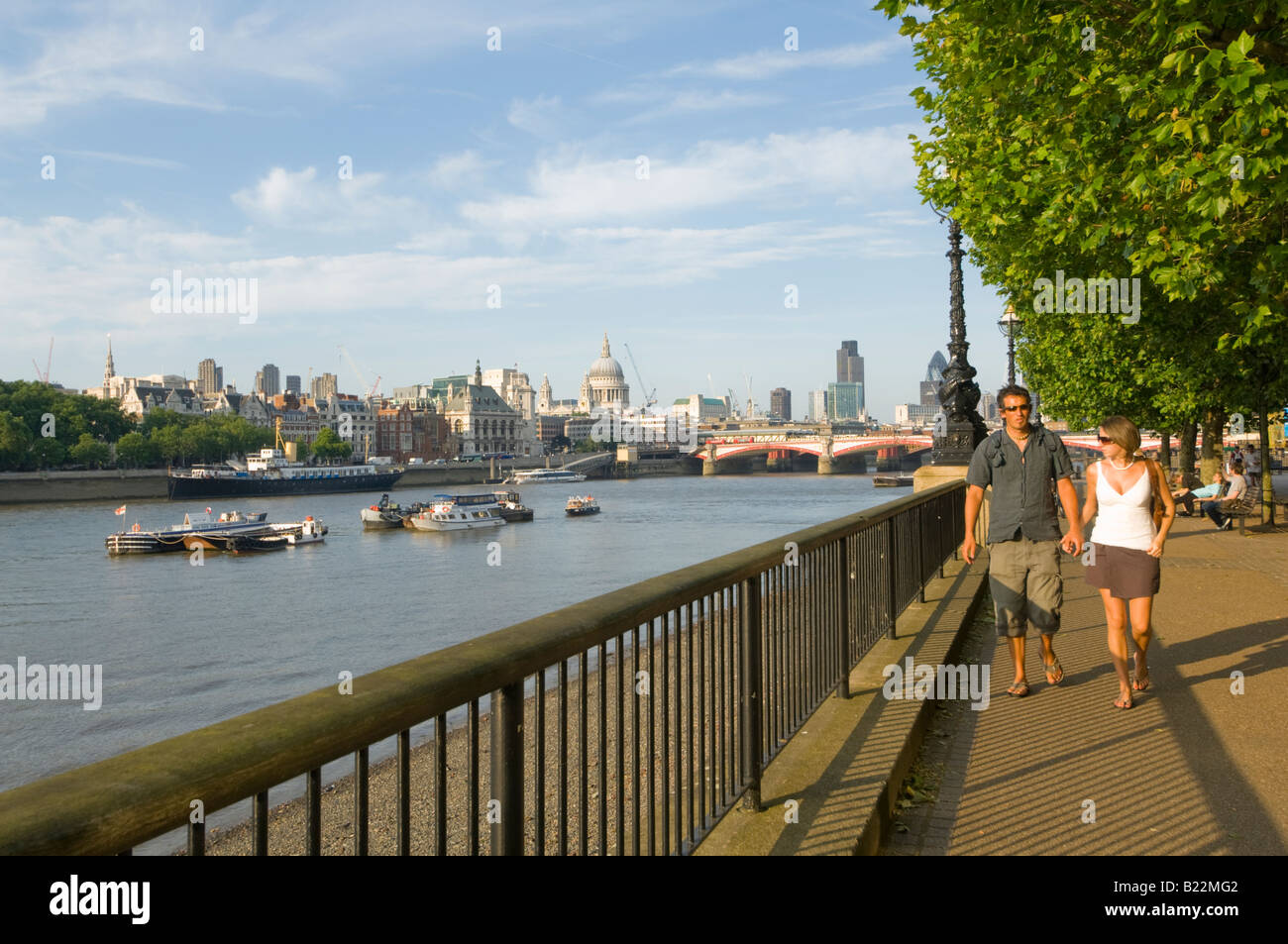 Couple se promener le long de la Tamise avec la ville et la Cathédrale St Paul dans la distance London UK Banque D'Images