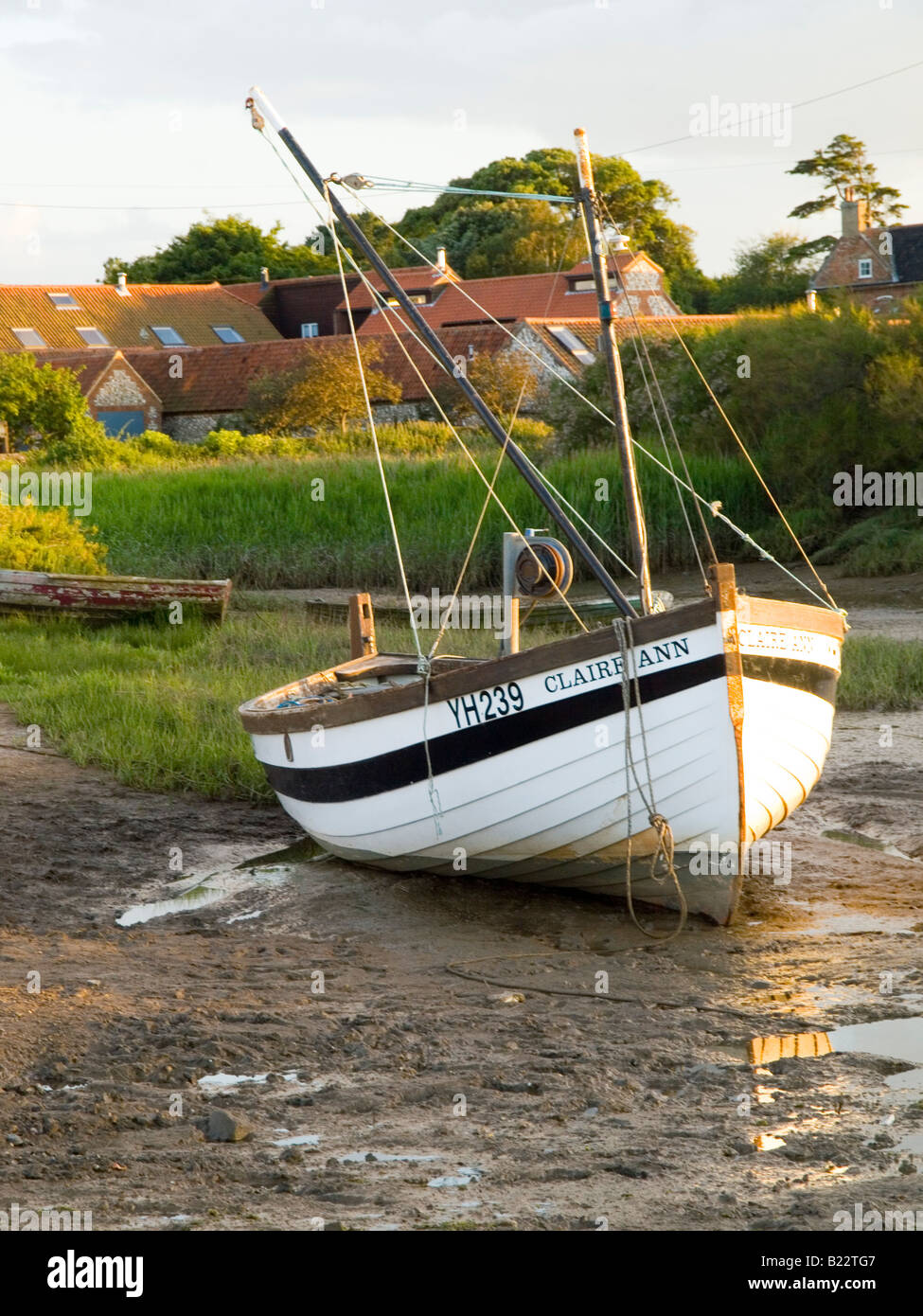 Un seul bateau sur la vase à marée basse dans le village de Burnham Deepdale sur la côte nord du comté de Norfolk dans l'East Anglia, Royaume-Uni Banque D'Images