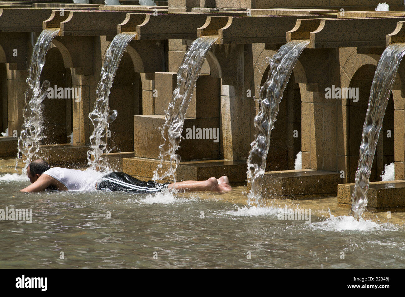 Un homme refroidit dans une fontaine publique pendant une vague de chaleur à Boston Ma. Banque D'Images
