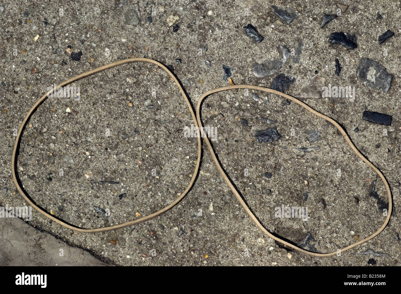 Close up de deux bandes en caoutchouc de forme ronde sur un trottoir en béton Banque D'Images