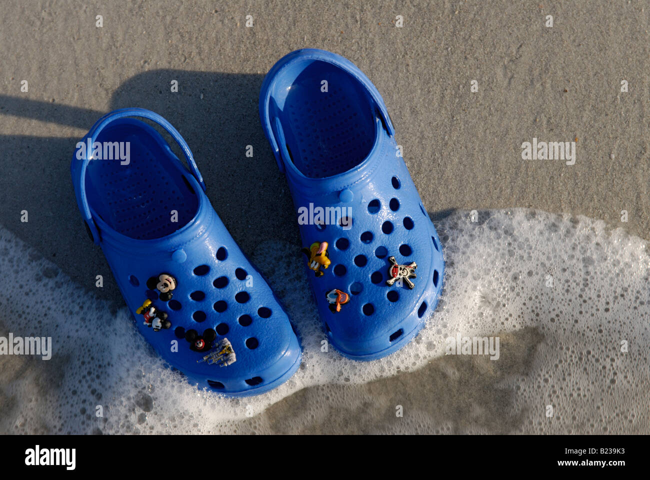 L'enfant chaussures Croc on beach Banque D'Images