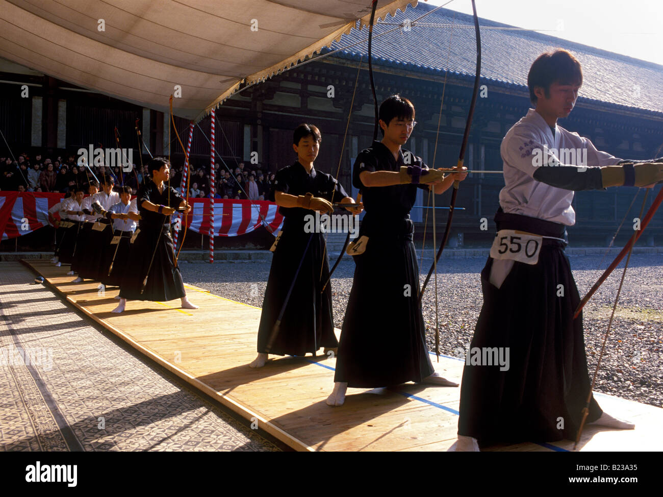 Hommes en tirant des flèches dans le hakama Toshiya au concours de tir à l'Temple Sanjūsangen-Dō à Kyoto au cours de la nouvelle année Banque D'Images