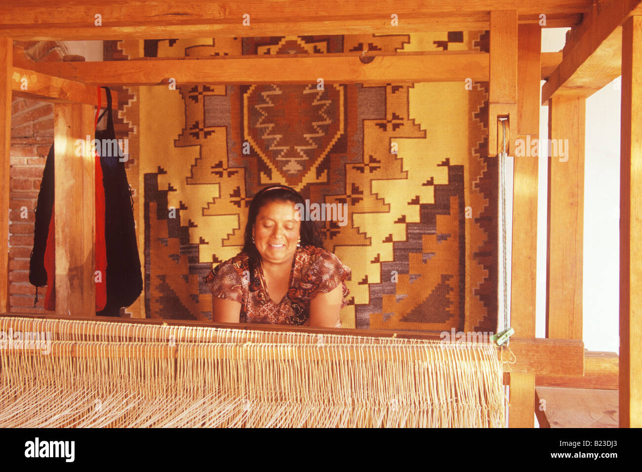 Femme tisse des tapis en laine sur un grand magasin de métier à tisser manuel Montano Sanchez Teotitlan Valle de Oaxaca au Mexique Banque D'Images