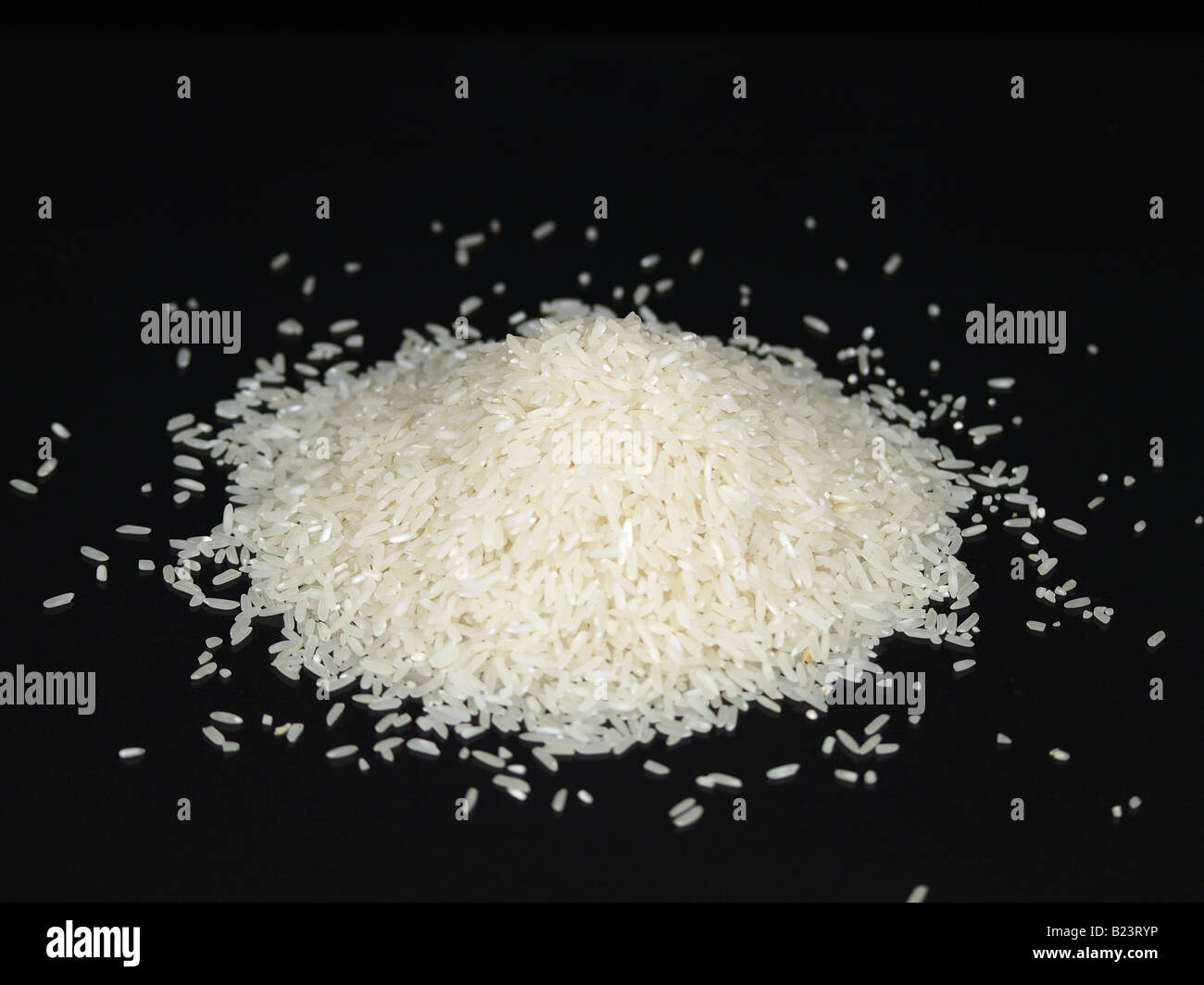 Un tas de riz à grains longs blanc sur une surface noire Banque D'Images