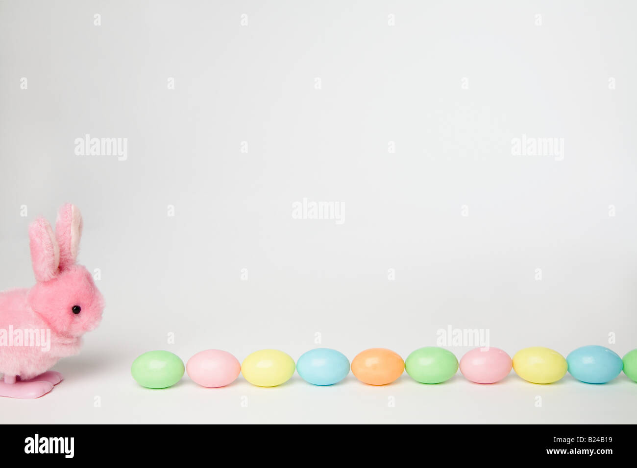 Un jouet lapin et oeufs de Pâques dans une rangée Banque D'Images