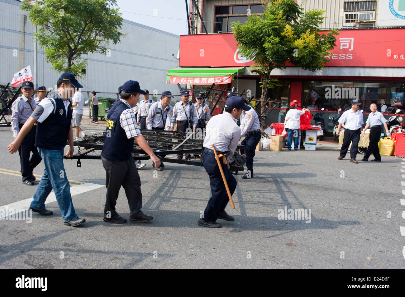 Les agents de police déplacer une barrière de barbelés en place avant d'une manifestation politique, Changhua, Taiwan, ROC Banque D'Images