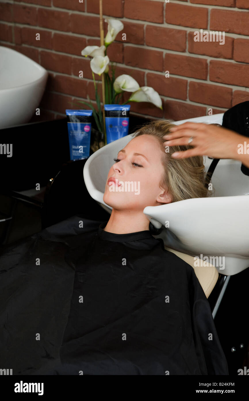 Jeune femme a cheveux lavés au lavabo dans Beauté Banque D'Images