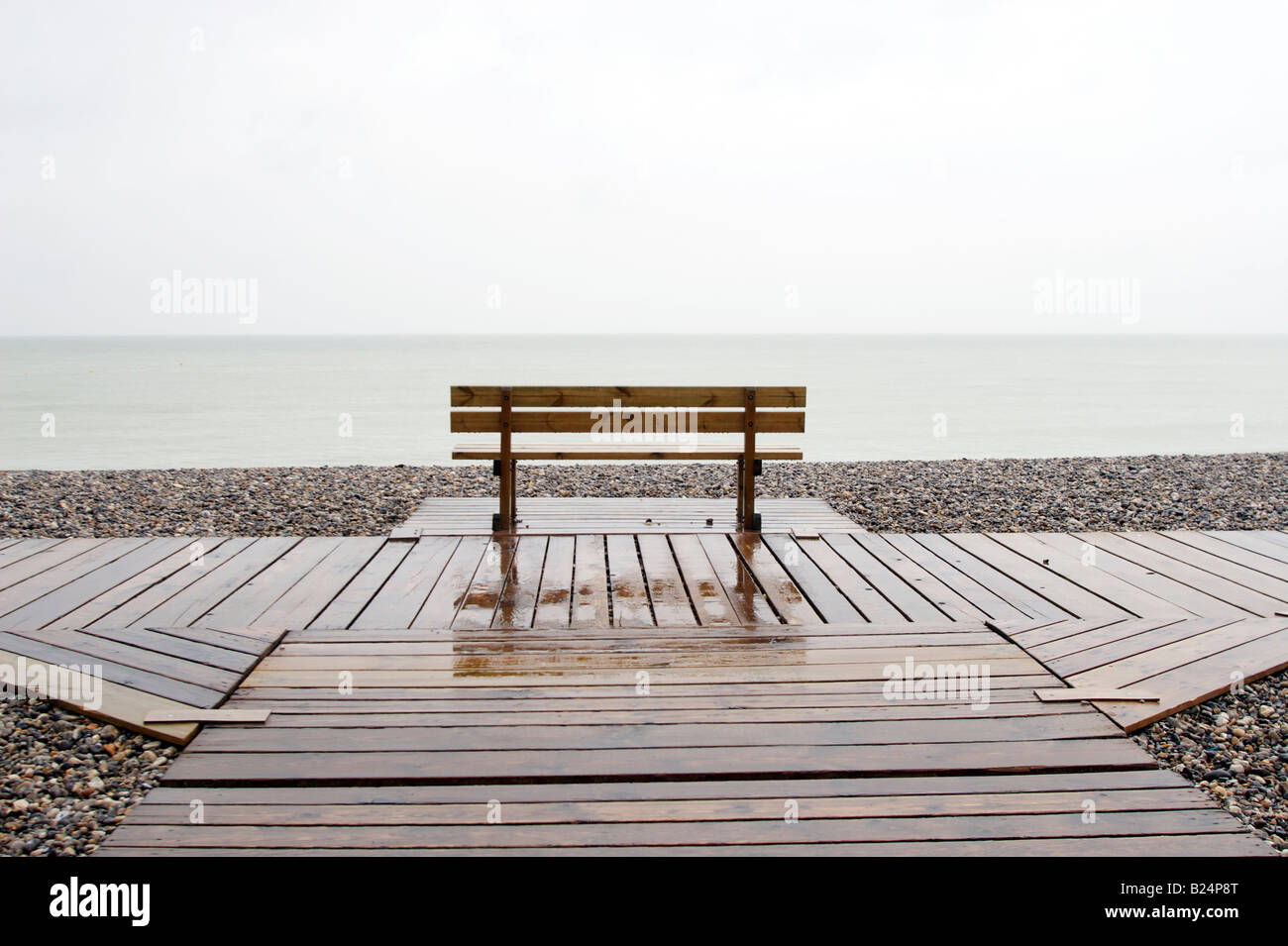 Un banc vide sous la pluie face à la mer près de St Valery sur Somme France Banque D'Images