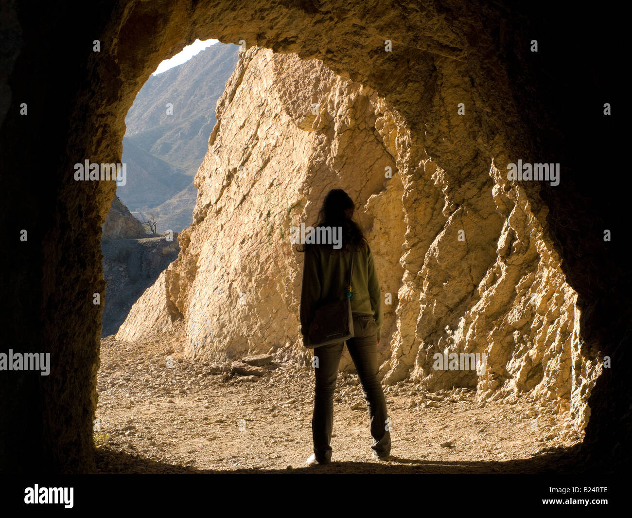 Femme silhouette sombre sur un côté d'un tunnel de montagne Banque D'Images