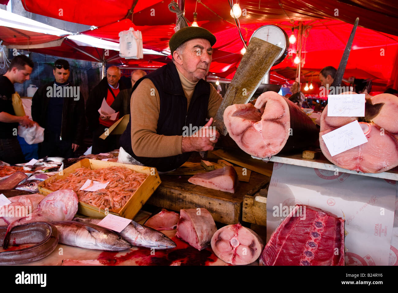 Vendeur de poisson réduit à l'espadons marché aux poissons de Catane Sicile Banque D'Images