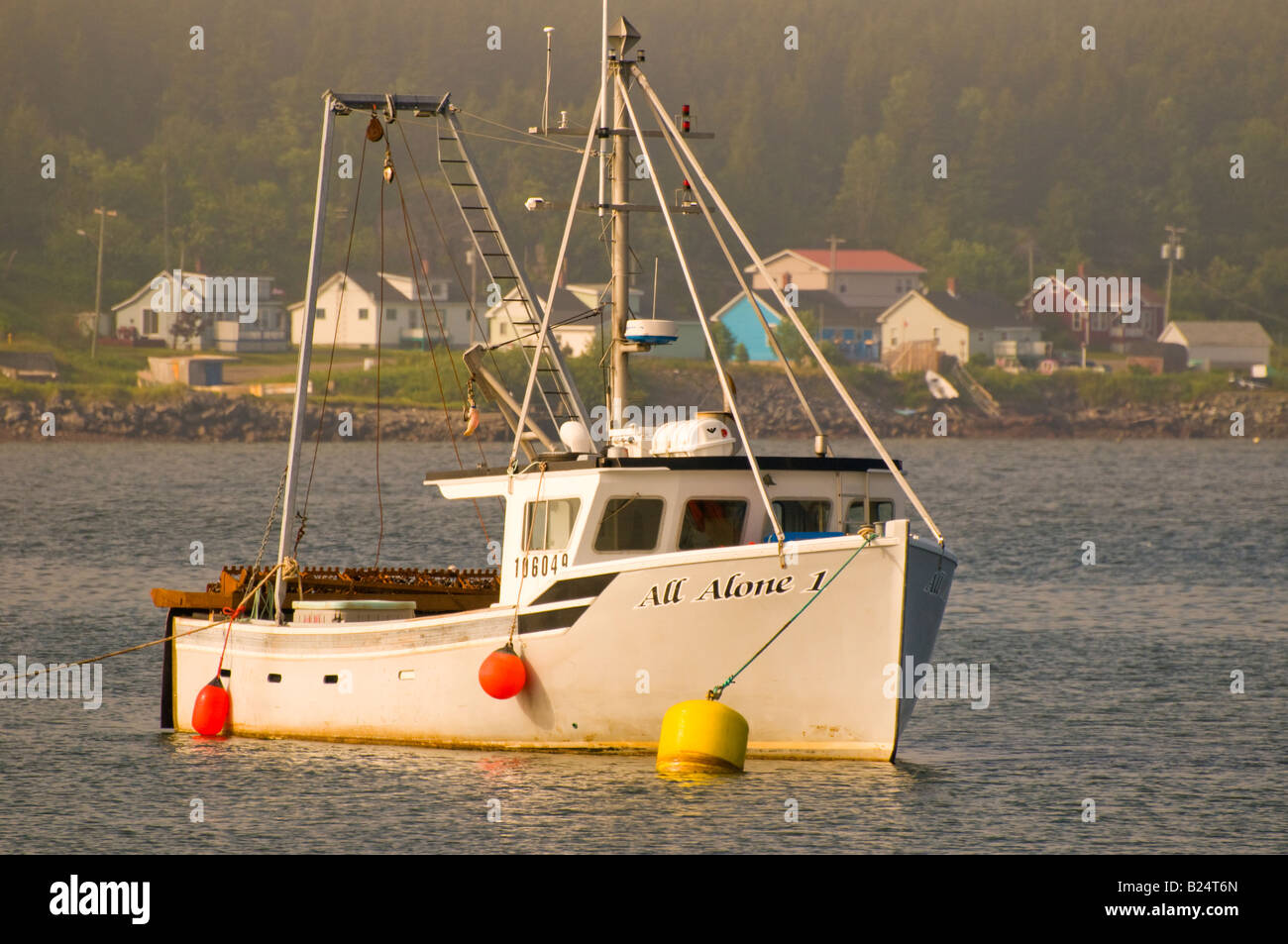 Canada Nouveau-brunswick bateau de pêche commerciale dans la baie de Fundy avec village de pêche colorés à distance Banque D'Images