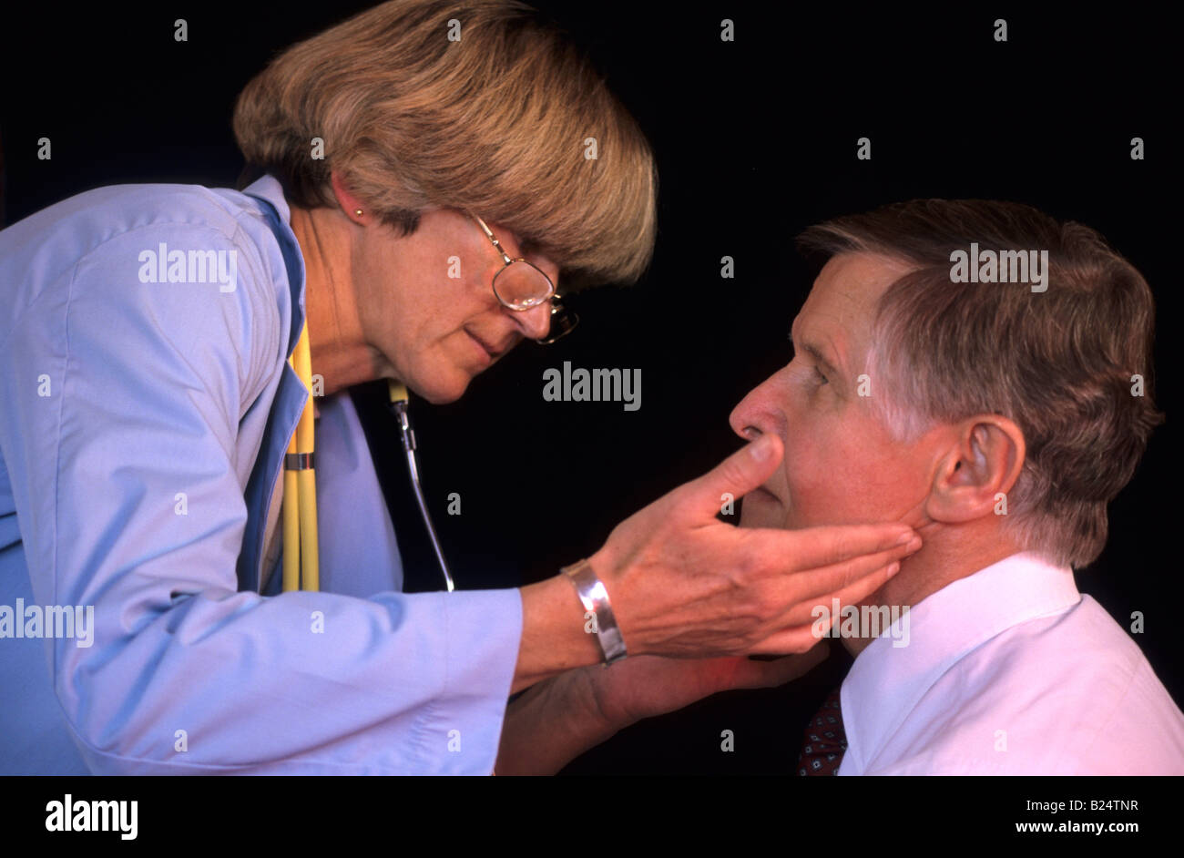 Femme médecin vérifie les ganglions lymphatiques du cou PT mâle Banque D'Images