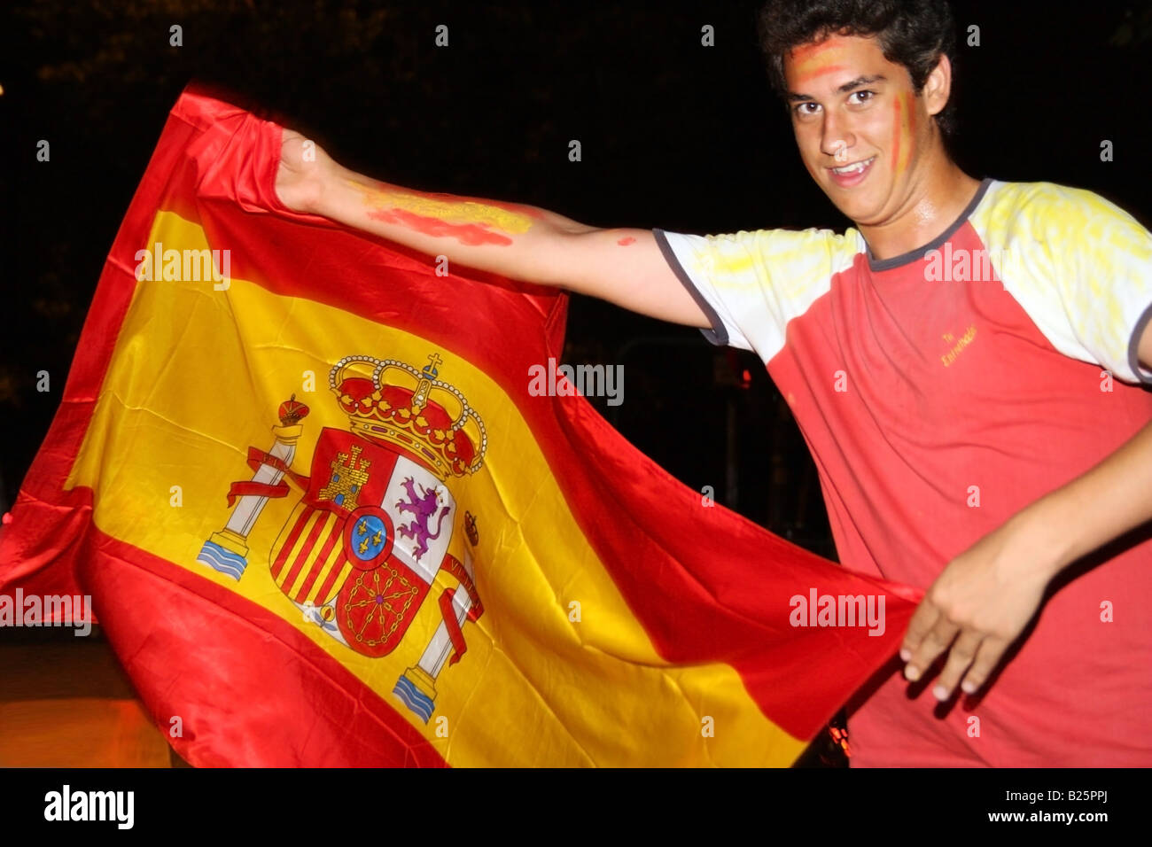 Man celebrating Espagne équipe de football victoire sur l'Allemagne dans l'UEFA EURO 2008 qui agitait un drapeau espagnol comme s'il était un toréador Banque D'Images