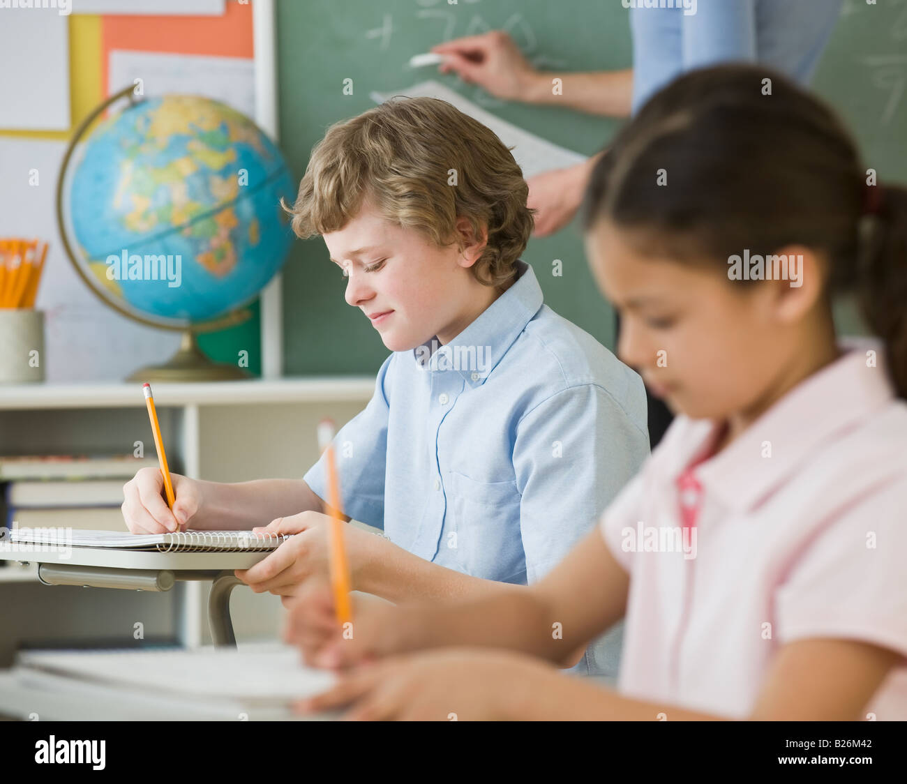 Les enfants multi-ethnique écrit à l'école d'un bureau Banque D'Images
