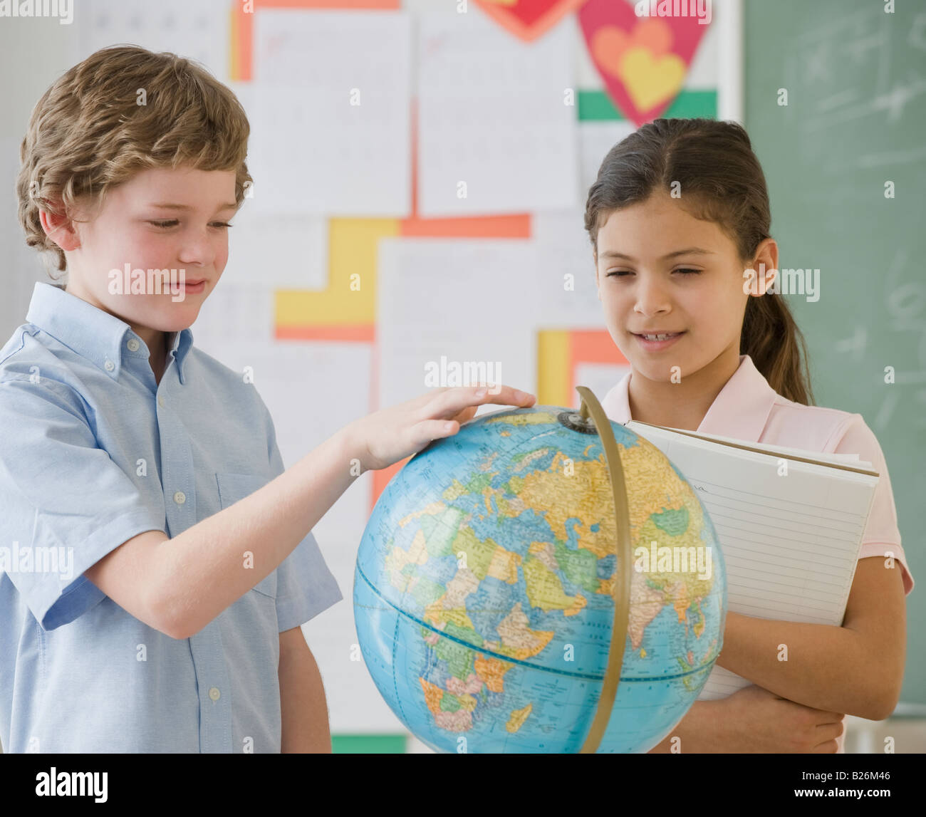 Les enfants de l'école multi-ethnique looking at globe Banque D'Images